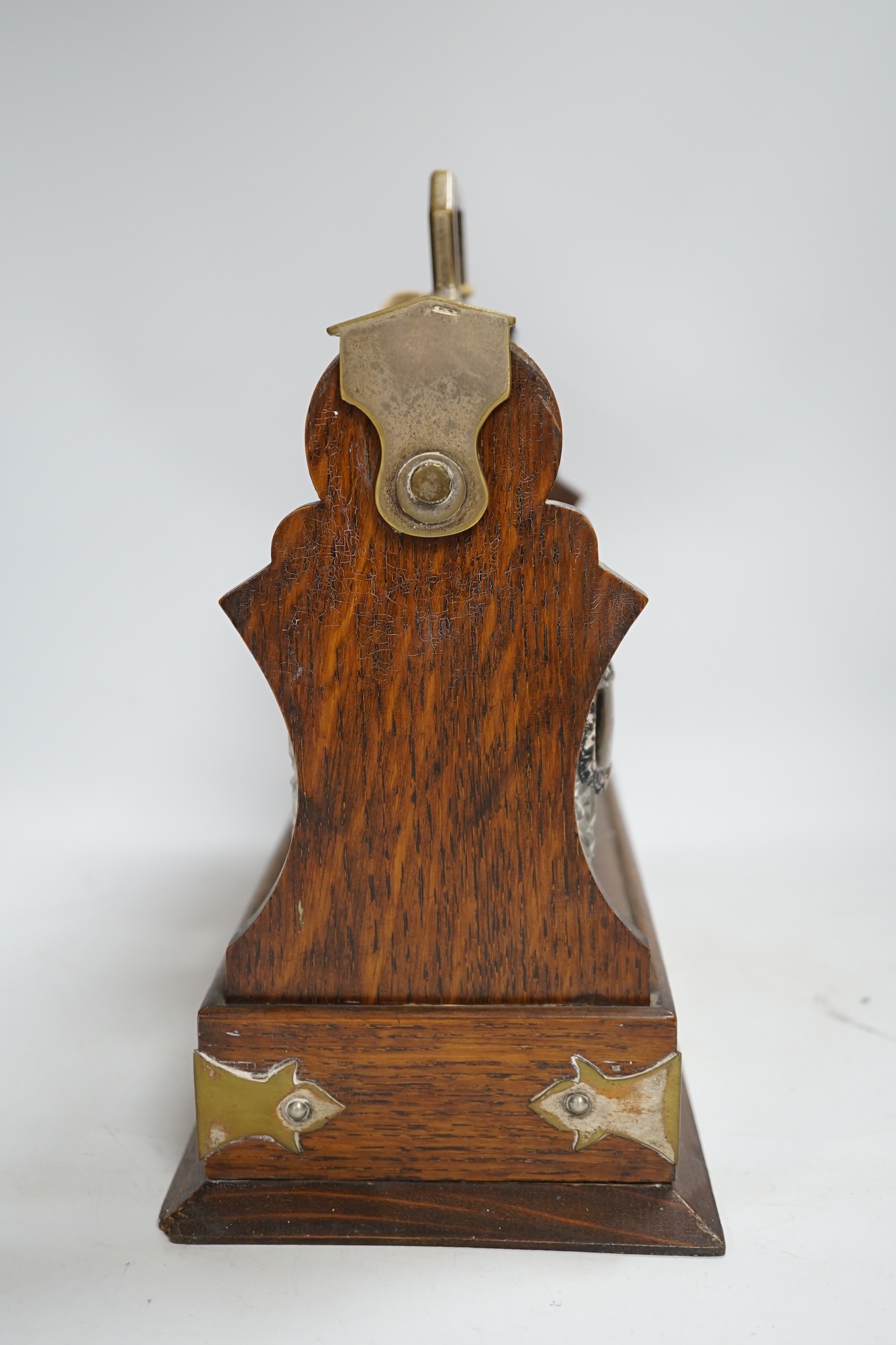 An oak three bottle electroplate tantalus, 29.5cm high